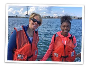 Woman and girl wearing life vests in boat